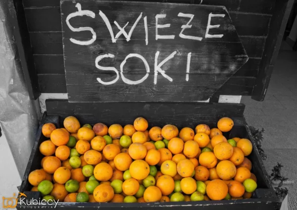 Drewniany znak z napisem ŚWIEŻE SOK! wypisanym białą kredą nad skrzynką wypełnioną świeżymi pomarańczami i limonkami. - Kubiccy Fotografia - Fotograf Łódź