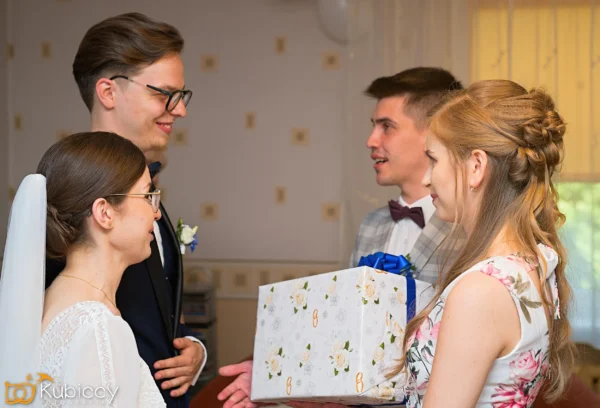 Grupa ludzi stojących wokół pudełka z prezentami. - Kubiccy Fotografia - Fotograf Łódź